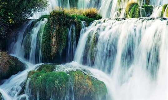 Water falling over mossy travertine steps at the Krka waterfalls