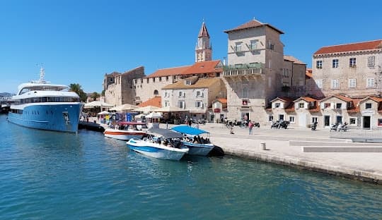 Trogir old town waterfront with a motor yacht moored at the quay